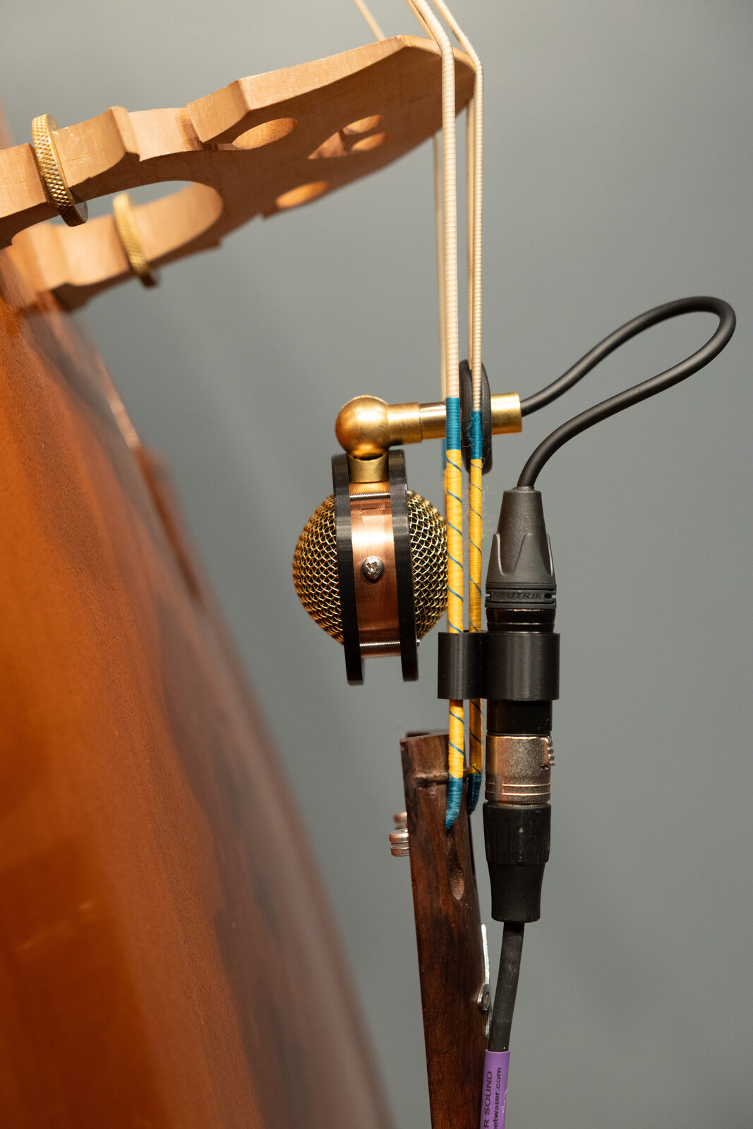 Chester V2 mounted between the strings behind the bridge, capsule facing the body
